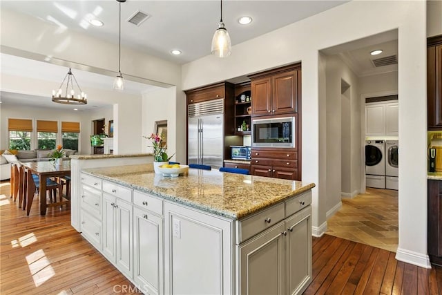 15 Pisano St, Ladera Ranch, CA 92694 - kitchen featuring built in appliances, washer and dryer, open shelves, open floor plan, and pendant lighting