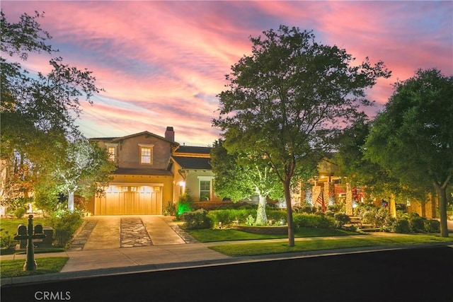 15 Pisano St, Ladera Ranch, CA 92694 - view of front of house featuring an attached garage, driveway, stucco siding, and a chimney