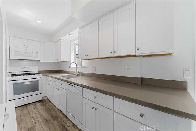 19859 Claremont Ln, Huntington Beach, CA 92646 - kitchen with white appliances, white cabinets, dark countertops, dark wood-style flooring, and recessed lighting