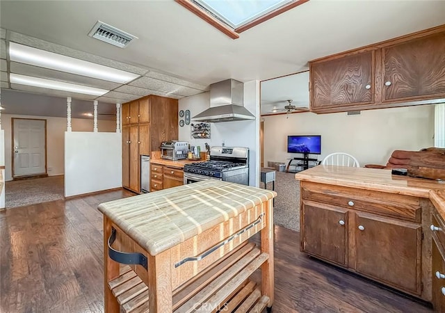 2191 Hilldale Ave, Simi Valley, CA 93063 - kitchen with wall chimney range hood, stainless steel gas stove, dark wood-type flooring, brown cabinets, and tile countertops