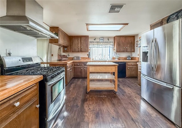 2191 Hilldale Ave, Simi Valley, CA 93063 - kitchen featuring appliances with stainless steel finishes, extractor fan, dark wood finished floors, wooden counters, and brown cabinets