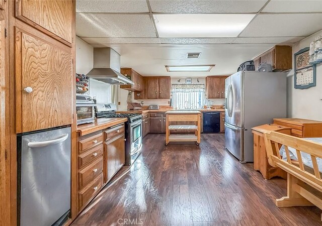 2191 Hilldale Ave, Simi Valley, CA 93063 - kitchen with appliances with stainless steel finishes, ventilation hood, dark wood-style floors, light countertops, and brown cabinets