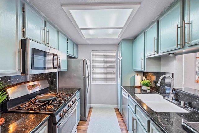 4658 Ohio St, San Diego, CA 92116 - kitchen featuring stainless steel appliances, light wood-type flooring, backsplash, and dark stone counters