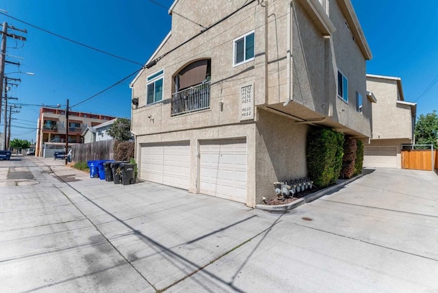 4658 Ohio St, San Diego, CA 92116 - view of side of home with an attached garage, driveway, and stucco siding