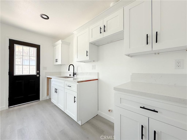 842 W Palmer St, Compton, CA 90220 - kitchen with light wood-type flooring, light countertops, and white cabinets