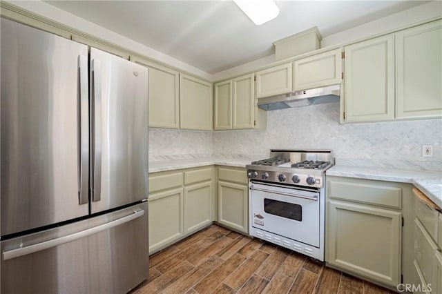 1584 Portola Way, Merced, CA 95348 - kitchen featuring freestanding refrigerator, gas stove, under cabinet range hood, dark wood-style flooring, and backsplash