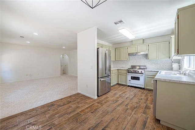 1584 Portola Way, Merced, CA 95348 - kitchen with high end white range oven, freestanding refrigerator, dark wood-style floors, under cabinet range hood, and recessed lighting