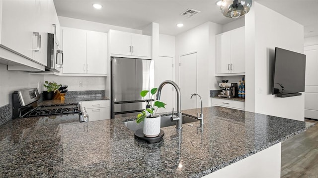 220 Perennial Pl, Fallbrook, CA 92028 - kitchen featuring appliances with stainless steel finishes, a peninsula, dark stone countertops, white cabinetry, and recessed lighting