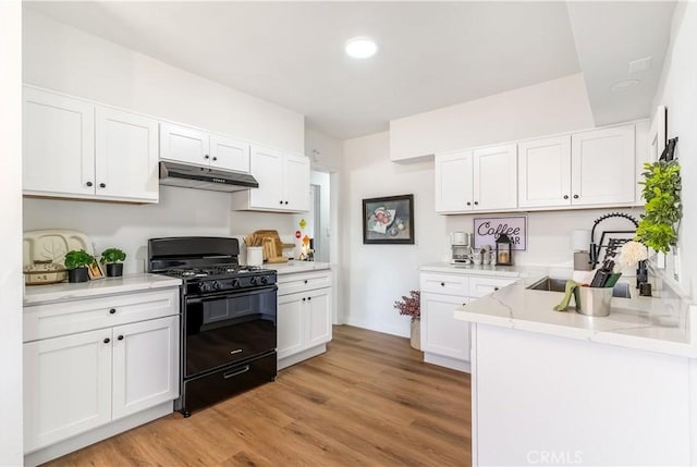 19436 Chaparral St, Rialto, CA 92376 - kitchen featuring black gas stove, under cabinet range hood, white cabinetry, light wood-type flooring, and recessed lighting