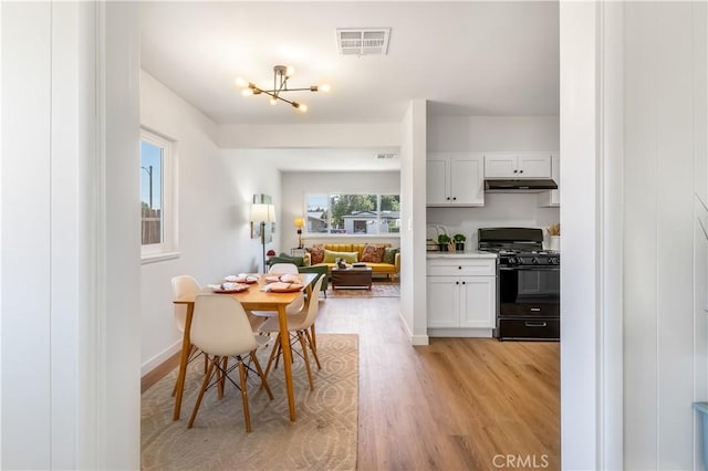 19436 Chaparral St, Rialto, CA 92376 - dining room with light wood-style floors and a chandelier