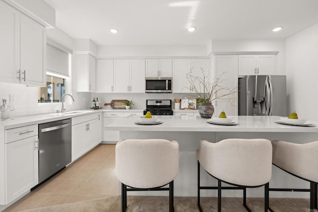 2310 Stardust Gln, Escondido, CA 92025 - kitchen featuring stainless steel appliances, a breakfast bar, decorative backsplash, white cabinetry, and recessed lighting