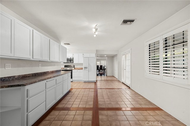 4790 Adam Rd, Simi Valley, CA 93063 - kitchen with white appliances, dark countertops, white cabinets, and light tile patterned floors