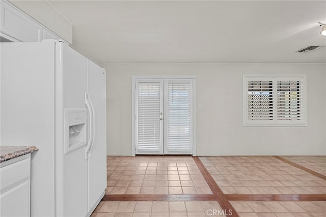 4790 Adam Rd, Simi Valley, CA 93063 - kitchen featuring white refrigerator with ice dispenser, inlaid floor details, light tile patterned floors, and white cabinetry