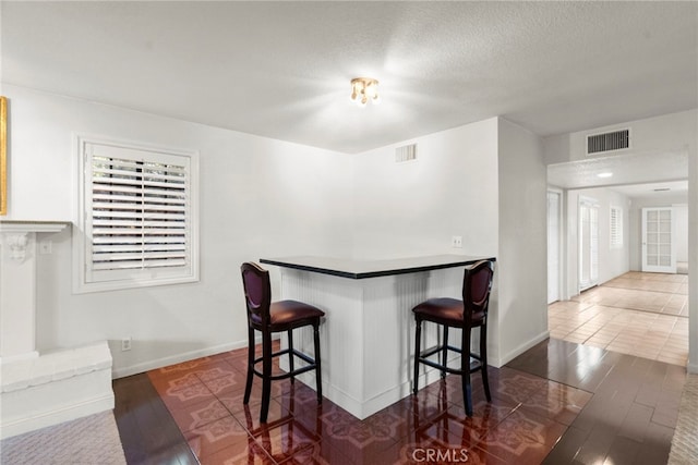 4790 Adam Rd, Simi Valley, CA 93063 - kitchen featuring healthy amount of natural light, a breakfast bar area, wood finished floors, and a textured ceiling