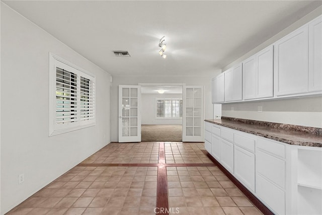 4790 Adam Rd, Simi Valley, CA 93063 - kitchen with french doors, dark countertops, white cabinetry, and light tile patterned floors