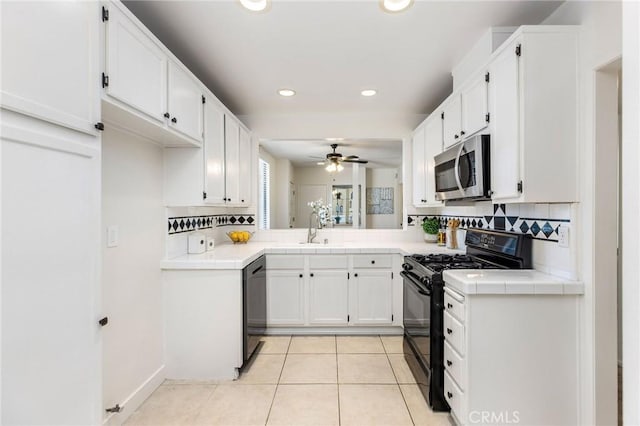 14315 Riverside Dr Unit 209, Sherman Oaks, CA 91423 - kitchen with stainless steel microwave, black gas range, tile countertops, white cabinetry, and decorative backsplash