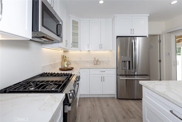 15256 Clymer St, San Fernando, CA 91345 - kitchen featuring stainless steel appliances, recessed lighting, white cabinetry, glass insert cabinets, and light wood finished floors