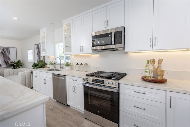 15256 Clymer St, San Fernando, CA 91345 - kitchen with appliances with stainless steel finishes, white cabinetry, light stone countertops, glass insert cabinets, and recessed lighting
