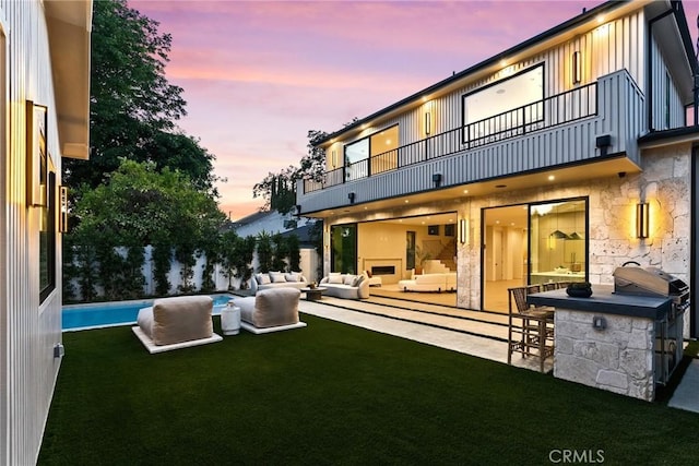 14738 Otsego St, Sherman Oaks, CA 91403 - back of property at dusk featuring a balcony, an outdoor living space, a patio, and a yard