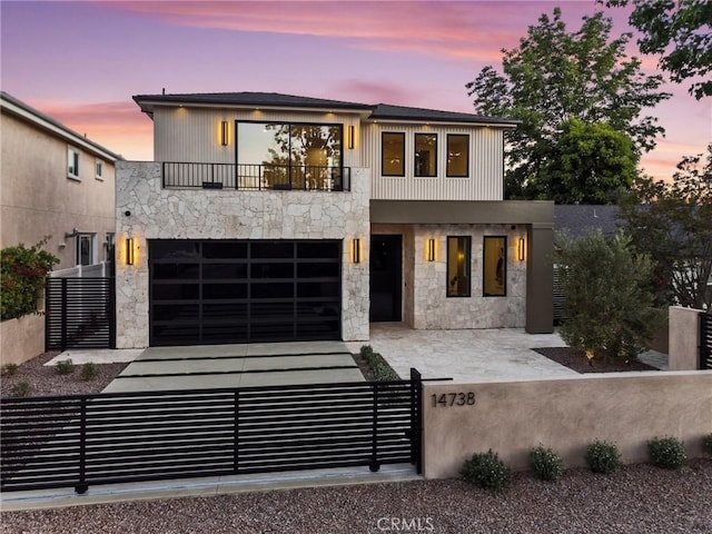 14738 Otsego St, Sherman Oaks, CA 91403 - modern home with a balcony, a fenced front yard, stone siding, and an attached garage