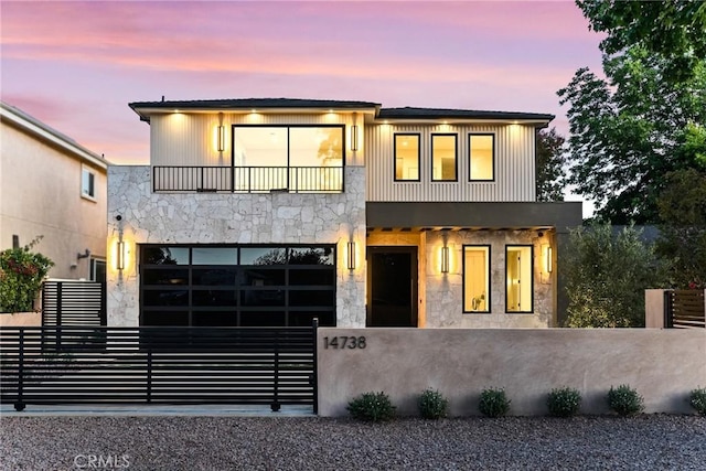 14738 Otsego St, Sherman Oaks, CA 91403 - modern home featuring a balcony, a fenced front yard, stone siding, and an attached garage