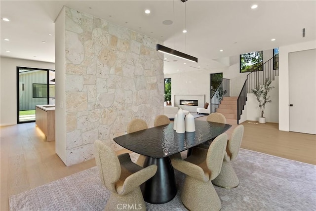 14738 Otsego St, Sherman Oaks, CA 91403 - dining area with light wood-style floors, a lit fireplace, stairs, and recessed lighting