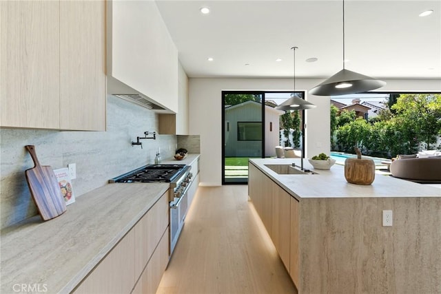 14738 Otsego St, Sherman Oaks, CA 91403 - kitchen featuring modern cabinets, high end range, light brown cabinets, light wood-style flooring, and a center island with sink