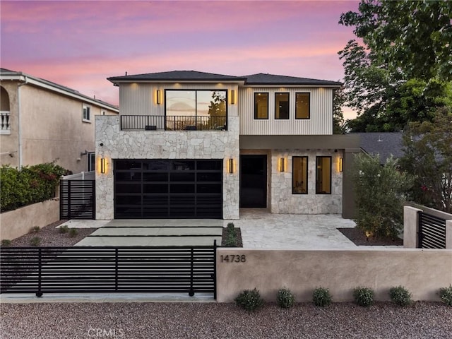 14738 Otsego St, Sherman Oaks, CA 91403 - contemporary home with a balcony, a fenced front yard, stone siding, a garage, and driveway
