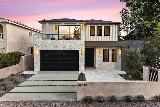 14738 Otsego St, Sherman Oaks, CA 91403 - contemporary home featuring an attached garage, stone siding, a balcony, and driveway