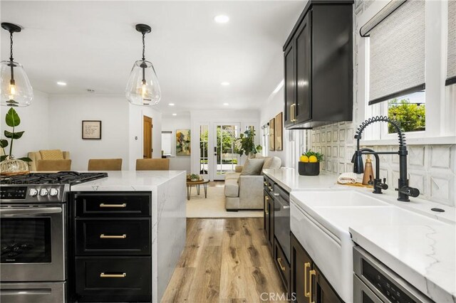 705 E Palm Ave, Orange, CA 92866 - kitchen with gas stove, dark cabinetry, light wood-style floors, open floor plan, and recessed lighting