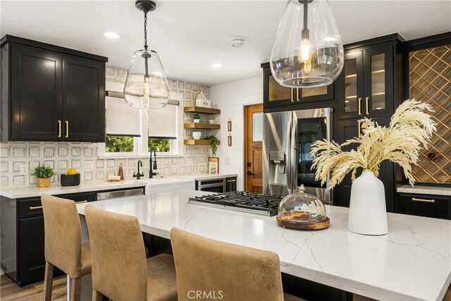 705 E Palm Ave, Orange, CA 92866 - kitchen featuring stainless steel refrigerator with ice dispenser, dark cabinetry, decorative backsplash, light stone counters, and recessed lighting