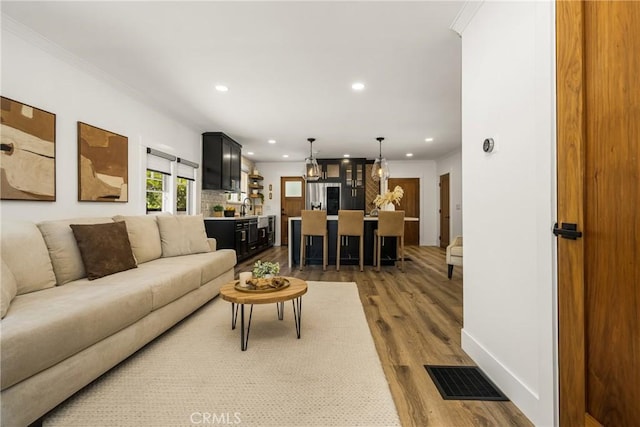 705 E Palm Ave, Orange, CA 92866 - living area with dark wood-type flooring, recessed lighting, and ornamental molding