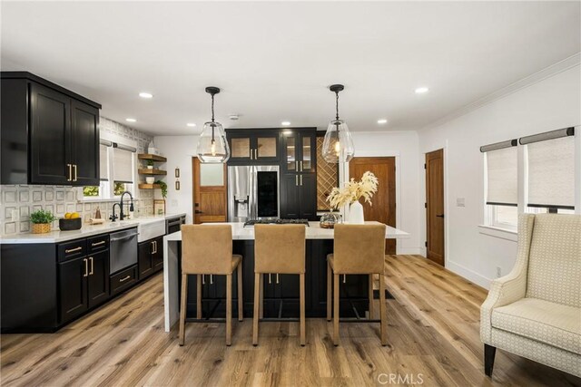 705 E Palm Ave, Orange, CA 92866 - kitchen with appliances with stainless steel finishes, backsplash, light countertops, a breakfast bar area, and dark cabinets