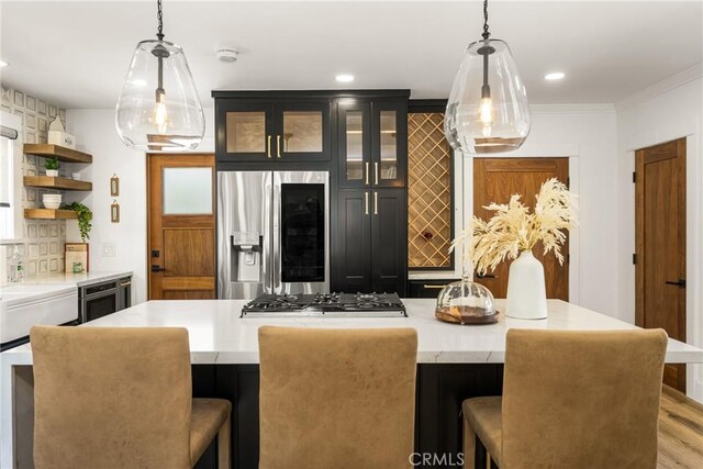 705 E Palm Ave, Orange, CA 92866 - kitchen with appliances with stainless steel finishes, open shelves, a breakfast bar area, glass insert cabinets, and crown molding