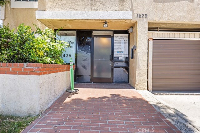 1629 Cherry Ave Unit 102, Long Beach, CA 90813 - doorway to property featuring stucco siding and a garage