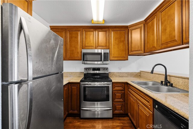 1629 Cherry Ave Unit 102, Long Beach, CA 90813 - kitchen with appliances with stainless steel finishes, dark wood-type flooring, light countertops, and brown cabinets