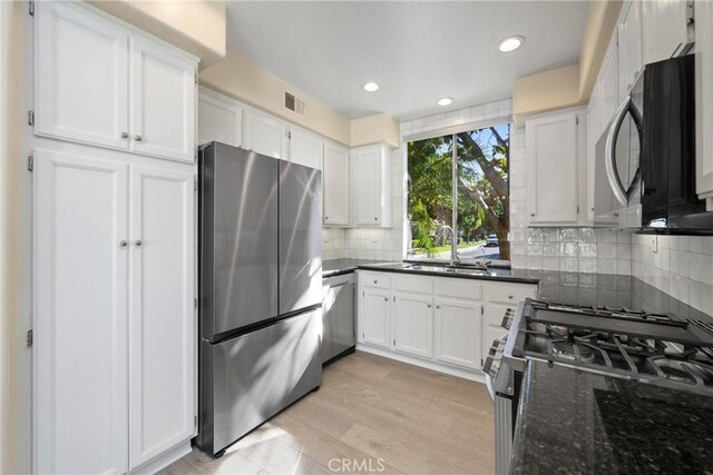 26 Le Vanto, Irvine, CA 92606 - kitchen featuring appliances with stainless steel finishes, white cabinets, backsplash, recessed lighting, and dark stone countertops
