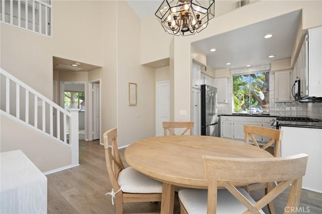 26 Le Vanto, Irvine, CA 92606 - dining room featuring plenty of natural light, a chandelier, light wood-style flooring, stairway, and recessed lighting
