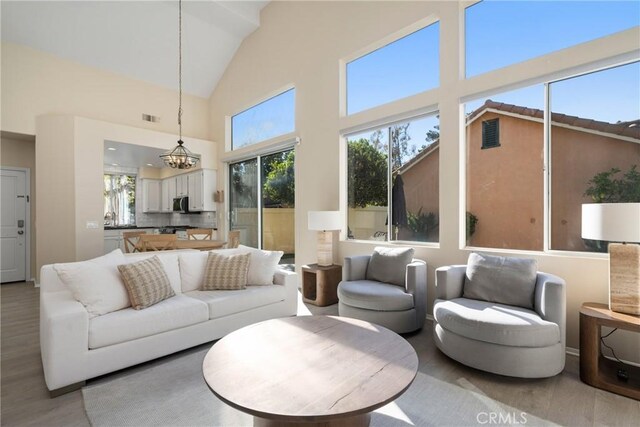 26 Le Vanto, Irvine, CA 92606 - living area with light wood-style floors, a towering ceiling, and a chandelier
