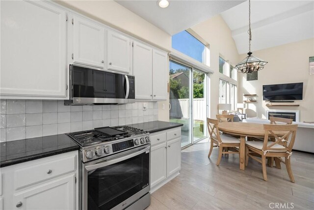 26 Le Vanto, Irvine, CA 92606 - kitchen featuring appliances with stainless steel finishes, dark countertops, a chandelier, white cabinetry, and lofted ceiling