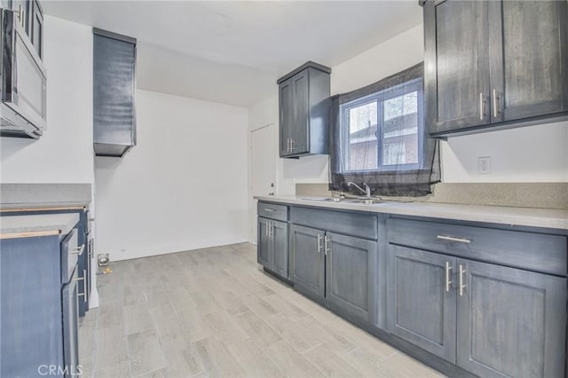 9218 Hooper Ave, Los Angeles, CA 90002 - kitchen with stainless steel microwave, light countertops, and light wood-style floors