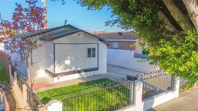 9218 Hooper Ave, Los Angeles, CA 90002 - view of home's exterior with a fenced front yard, stucco siding, and a storage shed