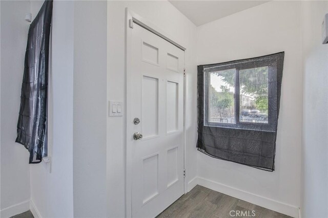 9218 Hooper Ave, Los Angeles, CA 90002 - doorway with baseboards and dark wood-style flooring