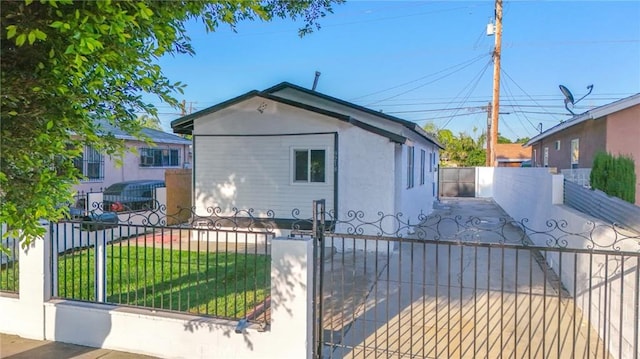 9218 Hooper Ave, Los Angeles, CA 90002 - view of side of property featuring a fenced front yard, stucco siding, and a gate
