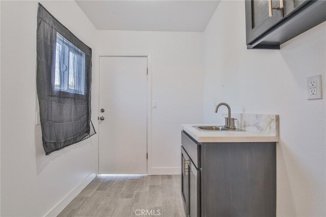 9218 Hooper Ave, Los Angeles, CA 90002 - laundry room with light wood-style floors and wet bar