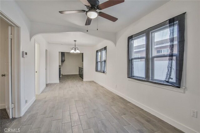 9218 Hooper Ave, Los Angeles, CA 90002 - unfurnished room featuring arched walkways, a chandelier, wood finished floors, and ceiling fan