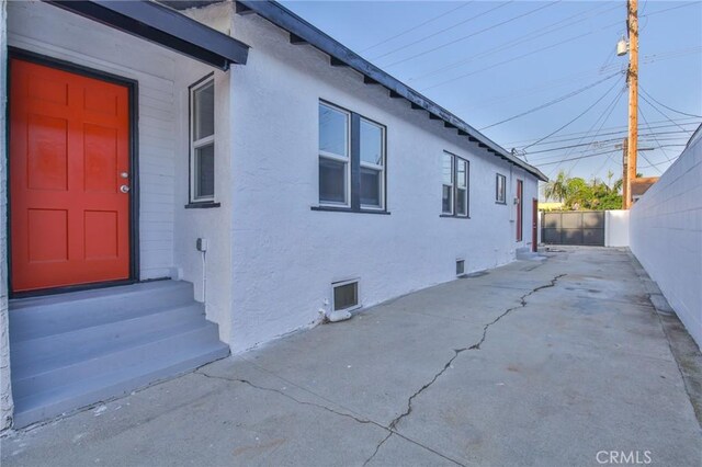 9218 Hooper Ave, Los Angeles, CA 90002 - view of side of property with entry steps, stucco siding, a fenced backyard, crawl space, and a patio