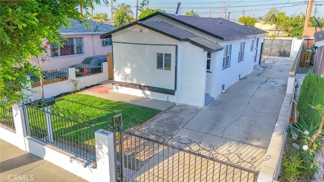 9218 Hooper Ave, Los Angeles, CA 90002 - view of side of home featuring a fenced front yard, stucco siding, and a gate