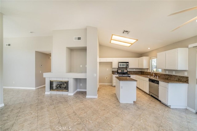 1870 S Jasmin Ct, Loma Linda, CA 92354 - kitchen with stainless steel appliances, vaulted ceiling, white cabinetry, a center island, and light tile patterned floors