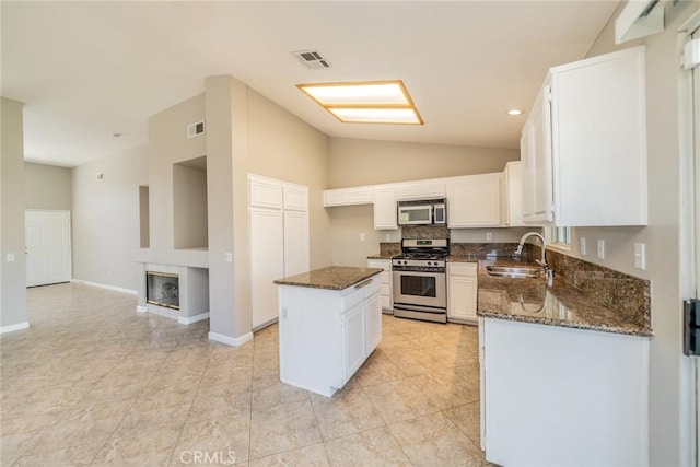 1870 S Jasmin Ct, Loma Linda, CA 92354 - kitchen with stainless steel appliances, dark stone counters, lofted ceiling, a center island, and white cabinetry